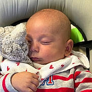 Louka participe au concours pour gagner de l'argent avec cette photo : baby, sleeping, stuffed_animal, bib, heart_pattern, striped_clothing, hand, face, close_up, cozy, child, infant, soft_toy, peaceful, cute, portrait, resting, indoor, cushion, childcare