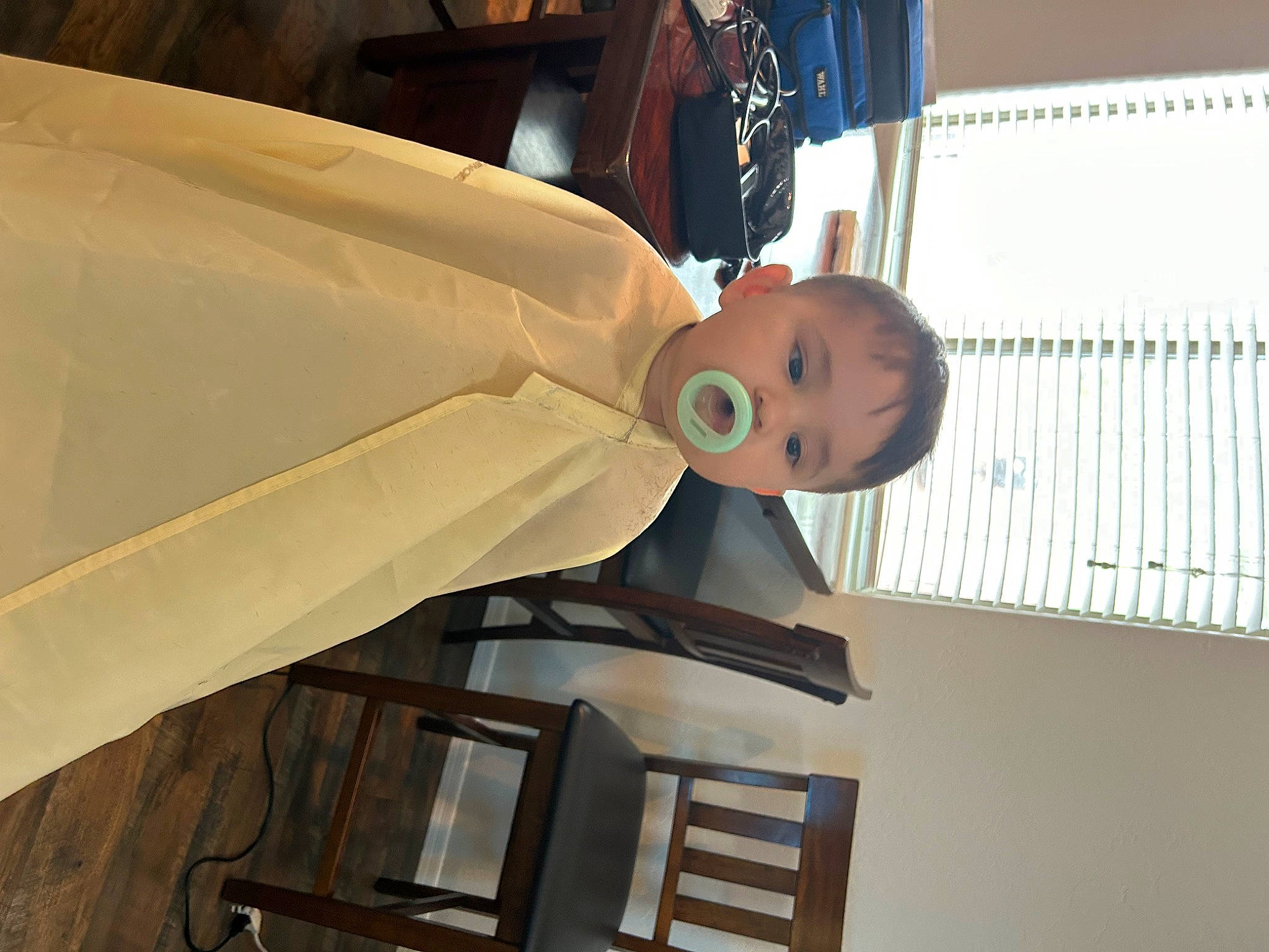 Lux is registered to the contest to win money with this photo: baby, ceiling, child, elbow, formal_wear, gesture, person, room, smile, suit, tie, toddler, wedding_dress, wood