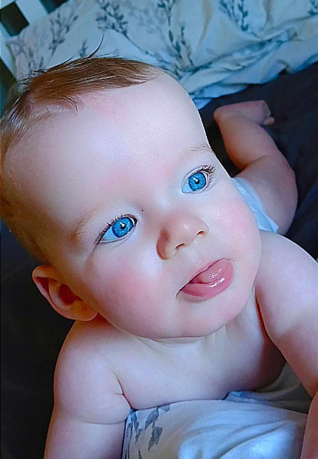 Colton joined the competition — help win amazing prizes! baby, blue_eyes, tongue_out, close_up, infant, cute, skin, face, head, arm, bed, blanket, soft, child, person, newborn, expression, playful, indoors, portrait