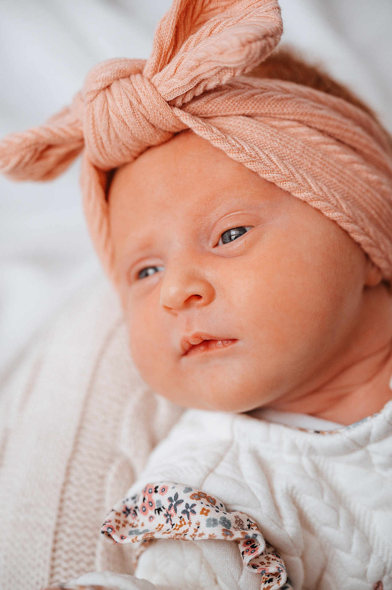 Maïlyne participe au concours pour gagner de l'argent avec cette photo : baby, infant, headwrap, knitwear, bow, closeup, face, blanket, soft, sleepy, portrait, young_child, white_clothing, floral_pattern, skin, cute, indoors, newborn, peaceful, baby_girl