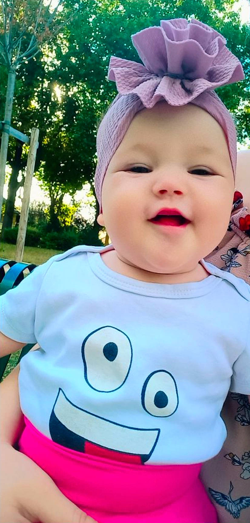 Romina participe au concours pour gagner de l'argent avec cette photo : baby_toddler_clothing, blue, face, facial_expression, gesture, green, hairstyle, happy, head, light, organ, person, photograph, pink, plant, product, skin, sleeve, smile, t_shirt