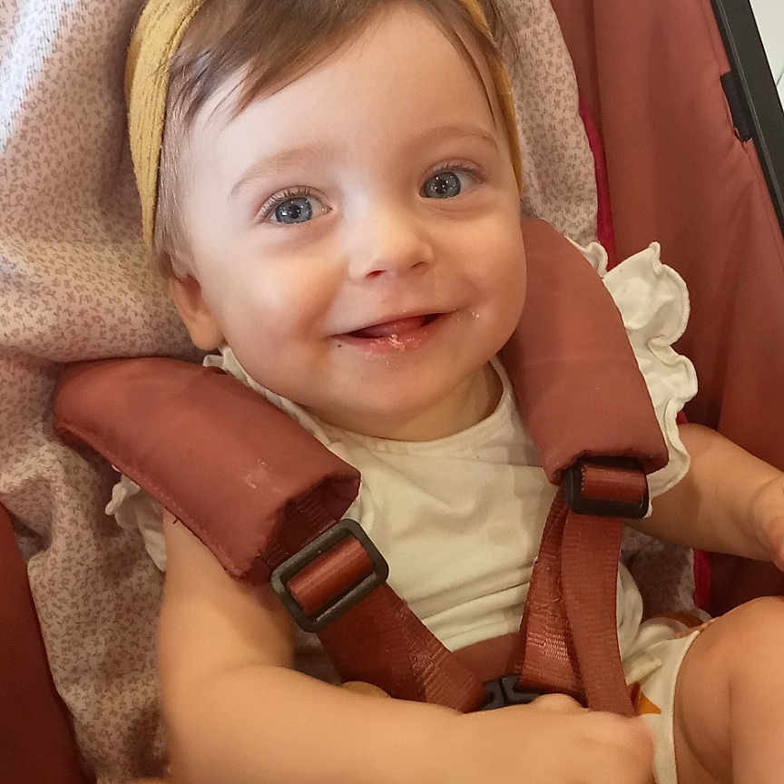 Lola a rejoint le concours — aidez-le/la à gagner de superbes lots ! baby, blue_eyes, cheerful, child, clothing, cute, fabric, face, happy, headband, indoors, infant, person, seat, seatbelt, smile, straps, stroller, toddler, young_child