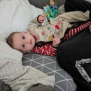 William participe au concours pour gagner de l'argent avec cette photo : baby, infant, couch, blanket, pillow, clothing, face, person, indoor, soft, cute, child, striped, pattern, fabric, relaxed, home, comfort, laying, looking