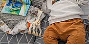 William a rejoint le concours — aidez-le/la à gagner de superbes lots ! baby, child, toy, blanket, pillow, sofa, clothing, socks, indoor, home, soft_toy, giraffe_toy, pattern, cushion, floor, person, resting, casual, infant, cozy