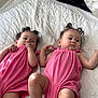 baby, babies, child, infant, twin, pink_clothing, bed, blanket, quilt, curly_hair, lying_down, indoors, cute, adorable, two_children, soft_light, skin, chubby_legs, young_child, peaceful