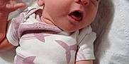Brilynn is registered to the contest to win money with this photo: baby, infant, onesie, whale_print, quilted_blanket, lying_down, expression, face, hand, arm, clothing, cute, newborn, skin, person, indoors, soft_light, portrait, child, sleepwear