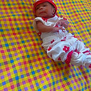 Miauna joined the competition — help win amazing prizes! baby, infant, child, blanket, patterned_blanket, colorful, red, white, hat, clothing, lying_down, cute, small, indoors, soft, resting, portrait, young, person, happy