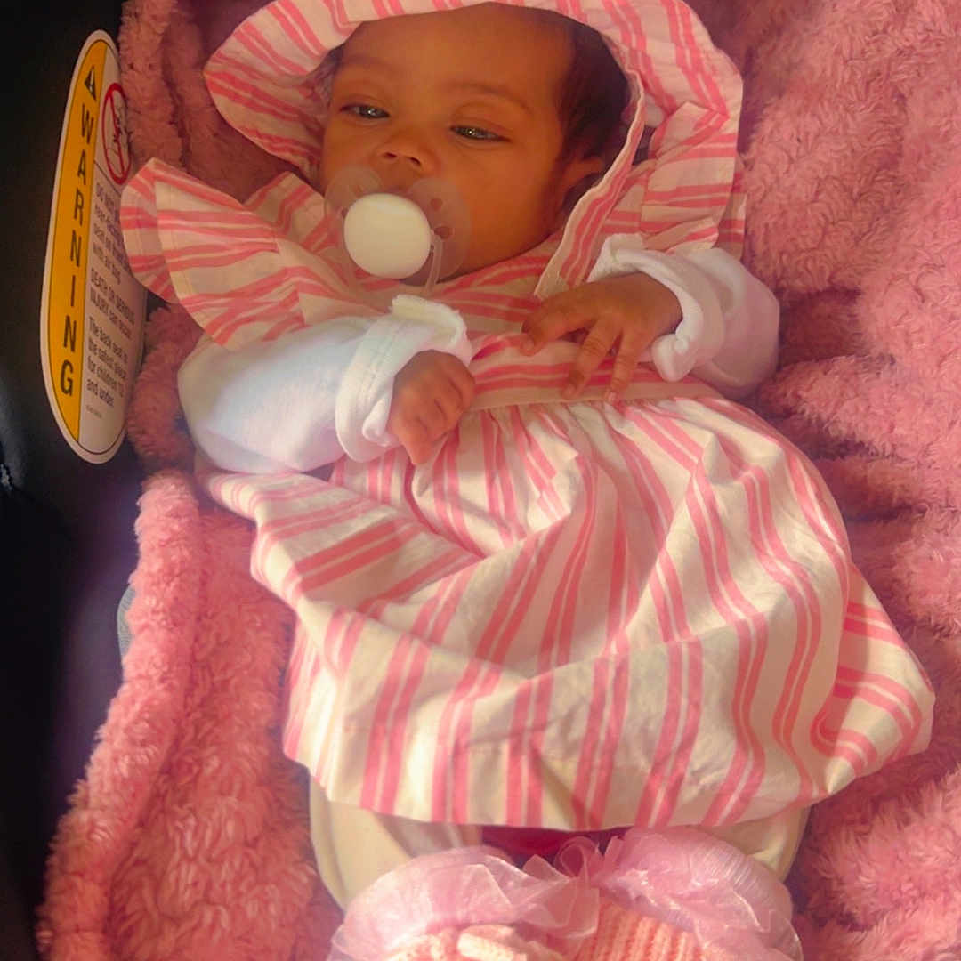 Miauna is registered to the contest to win money with this photo: baby, infant, pacifier, pink_blanket, car_seat, striped_clothing, hat, cute, adorable, cozy, newborn, child, soft_texture, knitted_booties, sleepy, indoor, portrait, warm, resting, toddler