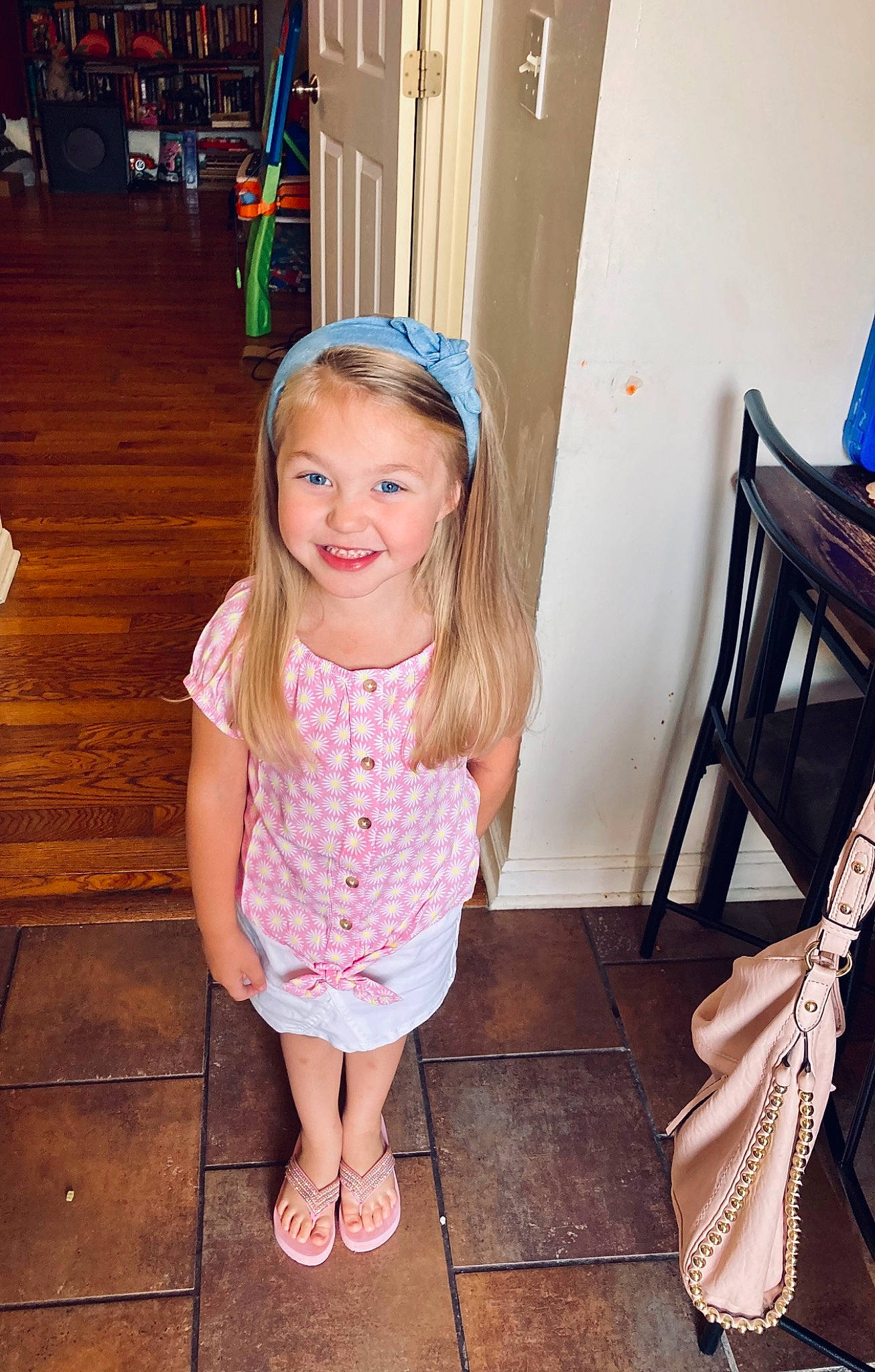 Carly is registered to the contest to win money with this photo: baby_toddler_clothing, blond, child, dress, eye, face, floor, flooring, fun, hair, happy, hardwood, head, human_body, human_leg, joy, leisure, person, smile, standing