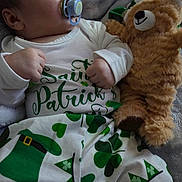 Mateo is registered to the contest to win money with this photo: baby, infant, pacifier, teddy_bear, plush_toy, st_patricks_day, green, shamrock, clothing, cute, sleepwear, person, portrait, indoors, blanket, resting, child, holiday, celebration, cozy
