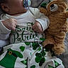 baby, infant, pacifier, teddy_bear, plush_toy, st_patricks_day, green, shamrock, clothing, cute, sleepwear, person, portrait, indoors, blanket, resting, child, holiday, celebration, cozy