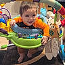 Mateo joined the competition — help win amazing prizes! baby, child, infant, smiling, happy, face, portrait, activity_center, jumper, toy, plush_owl, stuffed_animal, colorful, orange_shirt, indoor, playroom, carpet, furniture, dancing, family_photo