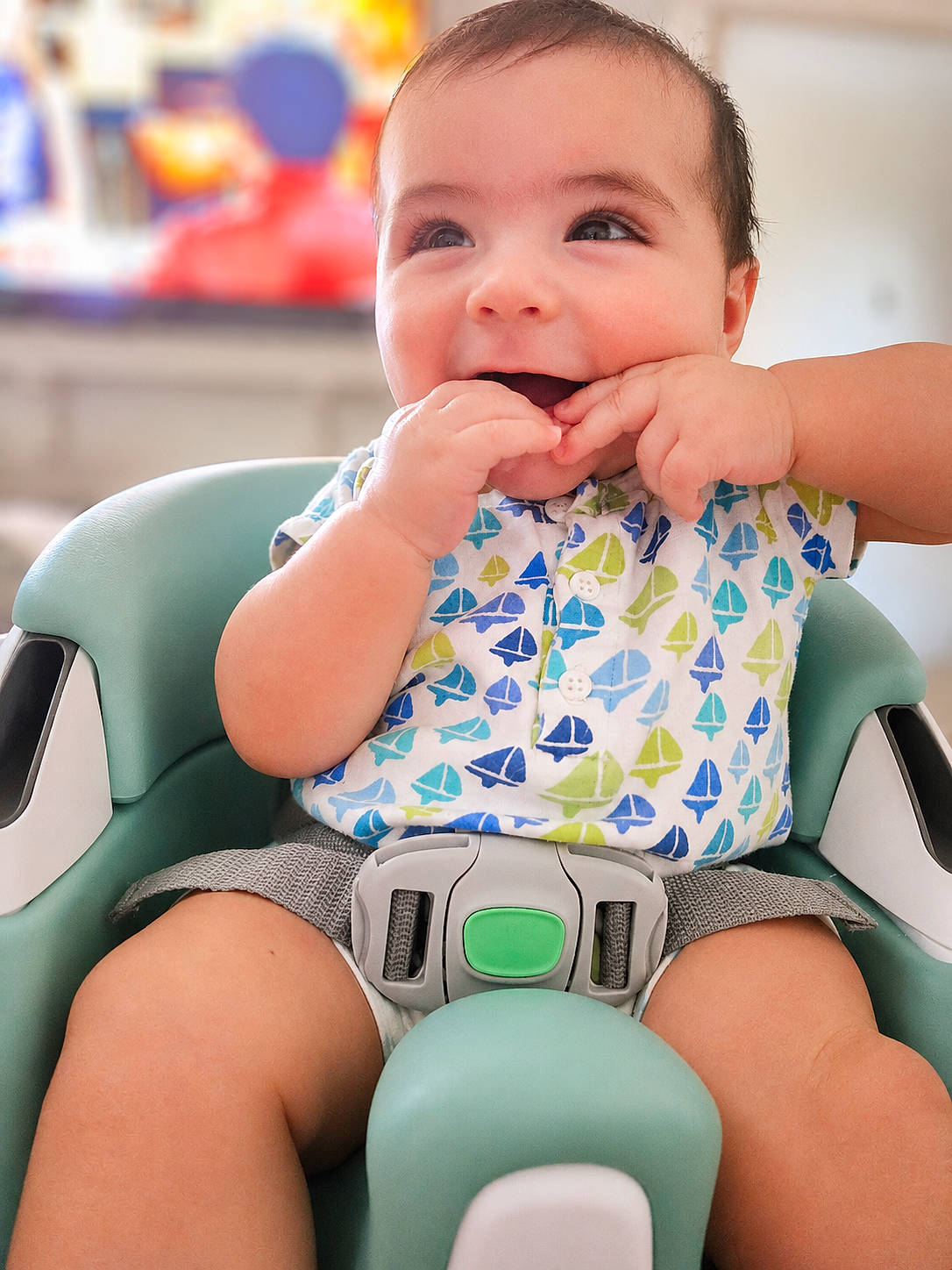 Mateo joined the competition — help win amazing prizes! baby, child, closeup, clothing, cute, face, hands, happy, high_chair, indoor, infant, pattern, person, playful, sailboat, seat, sitting, skin, smiling, young