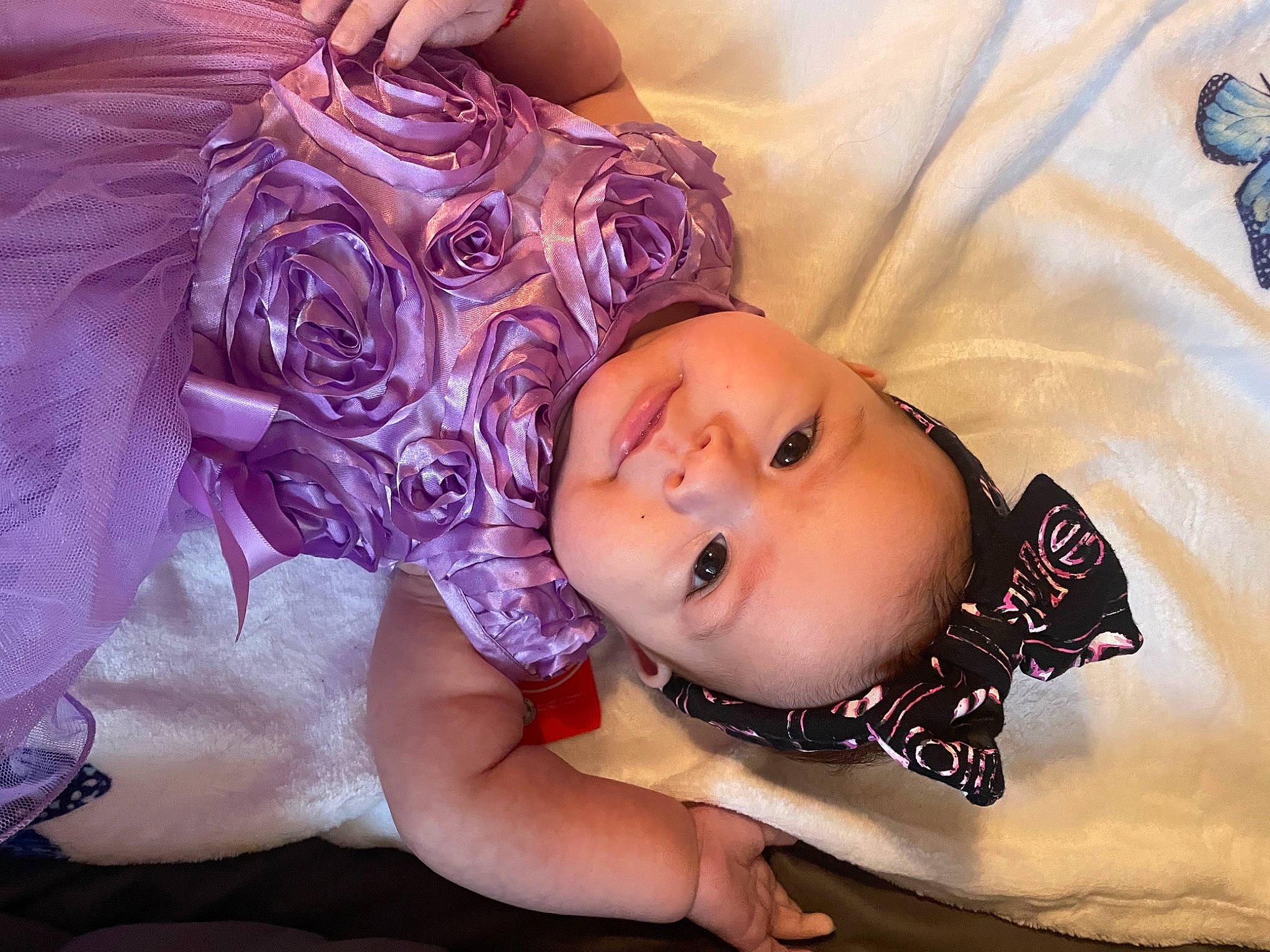 Martha is registered to the contest to win money with this photo: baby, baby_toddler_clothing, cheek, child, comfort, eye, eyelash, face, fashion_accessory, fun, happy, linens, mouth, pattern, person, portrait_photography, purple, skin, textile, toddler