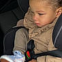 toddler, child, car_seat, jacket, sneaker, seatbelt, beige, clothing, hand, footwear, safety, car_interior, portrait, young_child, person, cute, travel, seat, closeup, casual