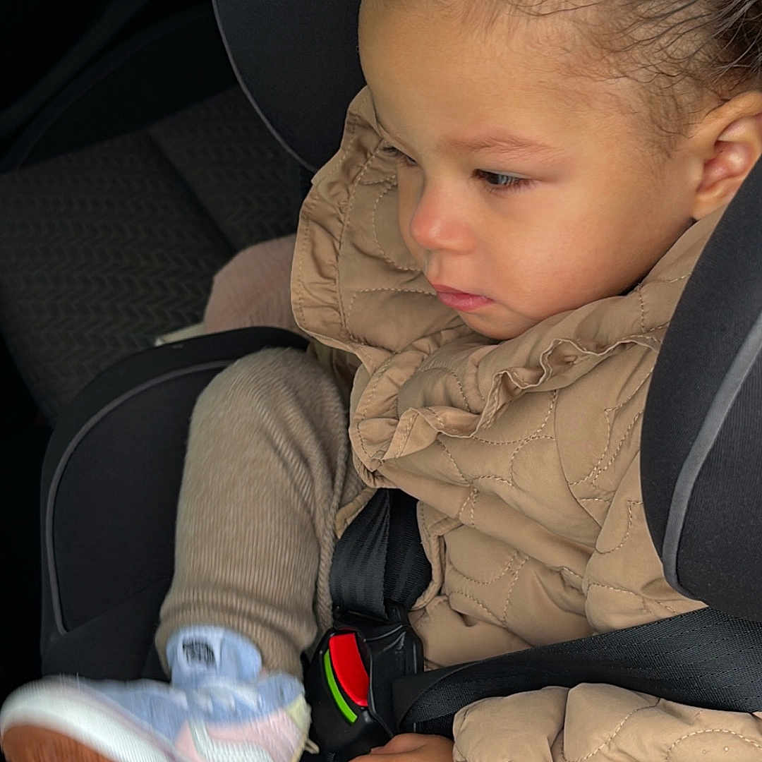 Israa a rejoint le concours — aidez-le/la à gagner de superbes lots ! beige, car_interior, car_seat, casual, child, closeup, clothing, cute, footwear, hand, jacket, person, portrait, safety, seat, seatbelt, sneaker, toddler, travel, young_child