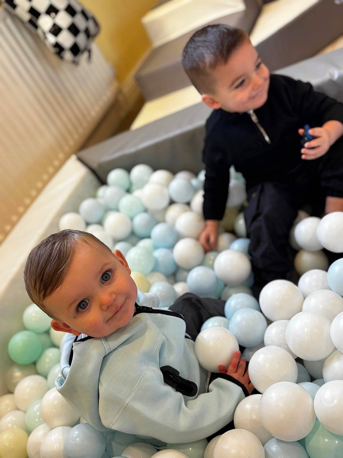 Eli is registered to the contest to win money with this photo: baby, boy, child, clothing, coat, crawling, face, formalwear, happy, head, jacket, male, pants, people, person, photography, portrait, sitting, sleeve, smile