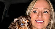 Milo joined the competition — help win amazing prizes! animal, blonde_hair, blue_eyes, car_interior, casual_clothing, close_up, cute, dachshund, dog, friendly, gold_jewelry, happy, holding, indoor, nose_ring, pet, portrait, puppy, smiling, woman