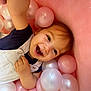 Mensïa participe au concours pour gagner de l'argent avec cette photo : toddler, child, smile, happy, ball_pit, pink, white, plastic_balls, overalls, clothing, face, portrait, baby, play, fun, indoor, cute, joy, hand, expression