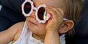Mensïa a rejoint le concours — aidez-le/la à gagner de superbes lots ! toddler, child, sunglasses, pink, flower_shaped, car_seat, white_clothing, pony_tail, hand, face, cute, summer, fashion, portrait, baby, seatbelt, indoor, casual, childhood, accessory