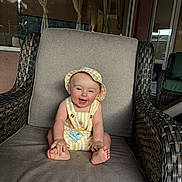 Luke joined the competition — help win amazing prizes! baby, child, infant, smiling, laughing, sitting, chair, patio, outdoor, sunhat, overalls, yellow_clothing, bare_feet, portrait, happy, furniture, wicker, cushion, home, family_photo