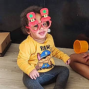 Kayden a rejoint le concours — aidez-le/la à gagner de superbes lots ! cardboard_box, child, clothing, face, floor, glasses, hair, happy, indoor, novelty_glasses, orange_cup, paw_patrol, person, playful, sitting, smile, toddler, toy_cup, wooden_floor, yellow_shirt