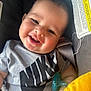 Jordan is registered to the contest to win money with this photo: baby, smiling, infant, nike_shirt, pacifier, car_seat, plush_toy, yellow, clothing, cute, happy, face, child, indoor, portrait, relaxed, person, young_child, closeup, comfort