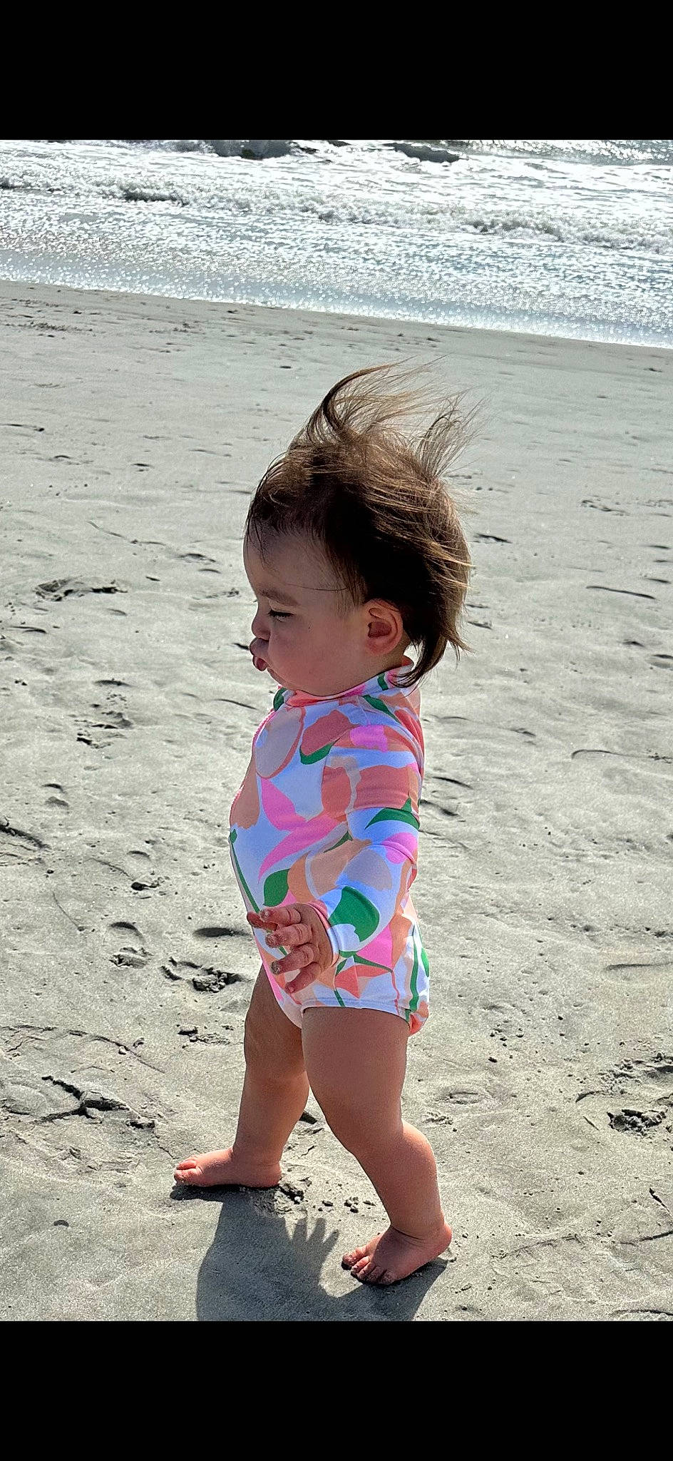 Sydney is registered to the contest to win money with this photo: baby_toddler_clothing, barefoot, beach, beauty, child, foot, fun, happy, human_leg, leisure, ocean, pattern, people_in_nature, people_on_beach, person, sand, skin, smile, thigh, toddler
