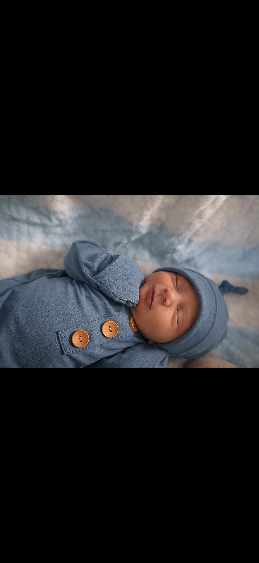 Onyx is registered to the contest to win money with this photo: newborn, baby, sleeping, blue_outfit, hat, wooden_buttons, blanket, soft_texture, closeup, infant, peaceful, resting, portrait, cozy, child, cute, indoors, warm, serene, clothing