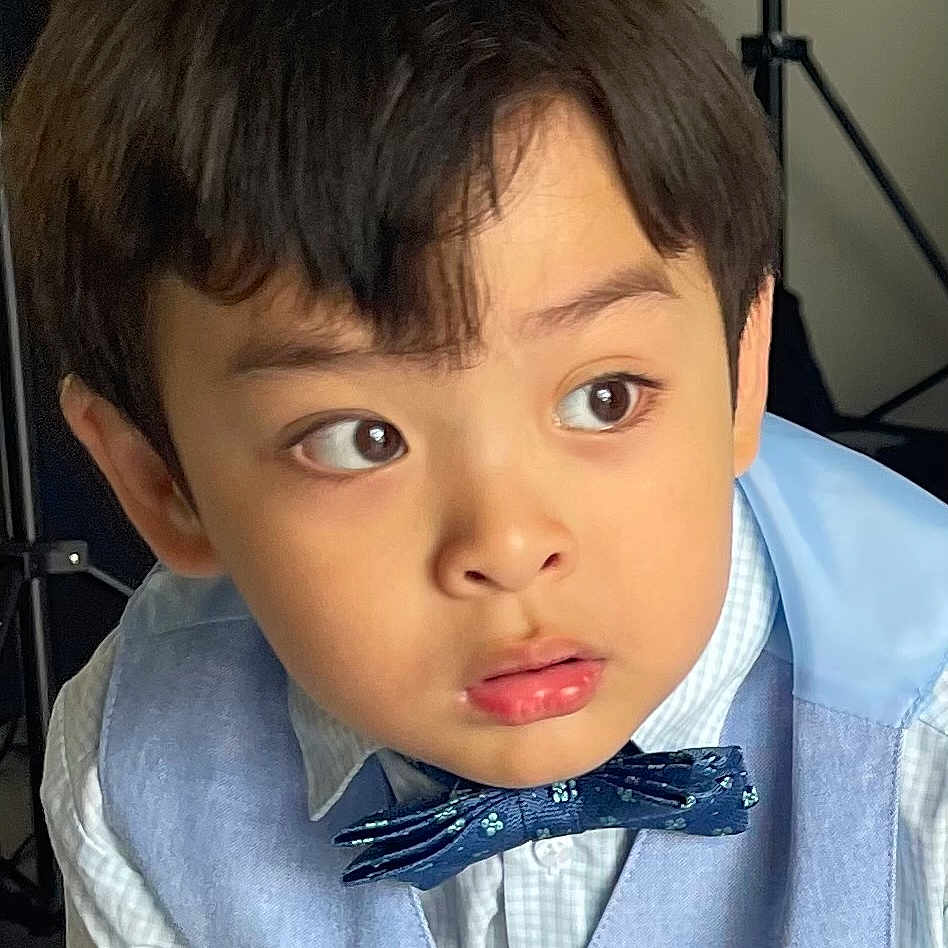 Kayden is registered to the contest to win money with this photo: child, boy, portrait, face, vest, bow_tie, curious, studio, lighting_equipment, clothing, young, expression, indoors, fashion, cute, person, hair, eyebrows, eyes, shirt