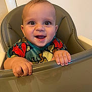 Theo joined the competition — help win amazing prizes! baby, bib, child, clothing, cute, expression, feeding_time, food, hands, happy, high_chair, indoor, infant, messy_face, person, playful, portrait, seat, smiling, young