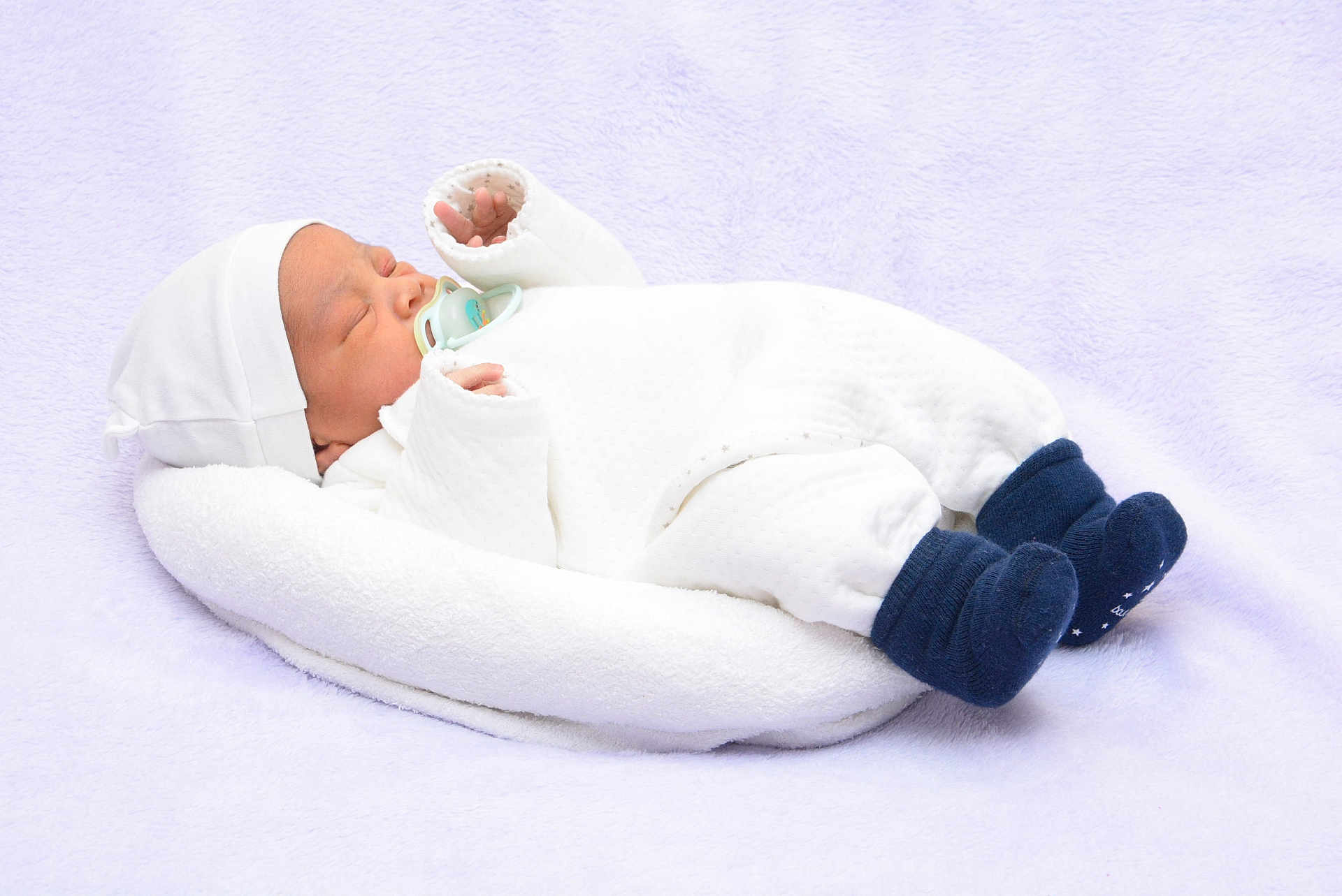 Noah Valentin a rejoint le concours — aidez-le/la à gagner de superbes lots ! baby, newborn, infant, pacifier, sleeping, hat, blanket, white_clothing, socks, baby_bed, cozy, soft_texture, nursery, peaceful, closeup, portrait, lying_down, studio_photo, blue_socks, cuteness