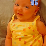 Meadow Azalea is registered to the contest to win money with this photo: baby, child, smiling, yellow_clothing, polka_dot, butterflies, indoor, cute, happy, infant, portrait, sitting, playful, soft_light, closeup, face, cheerful, young_child, fun, colorful