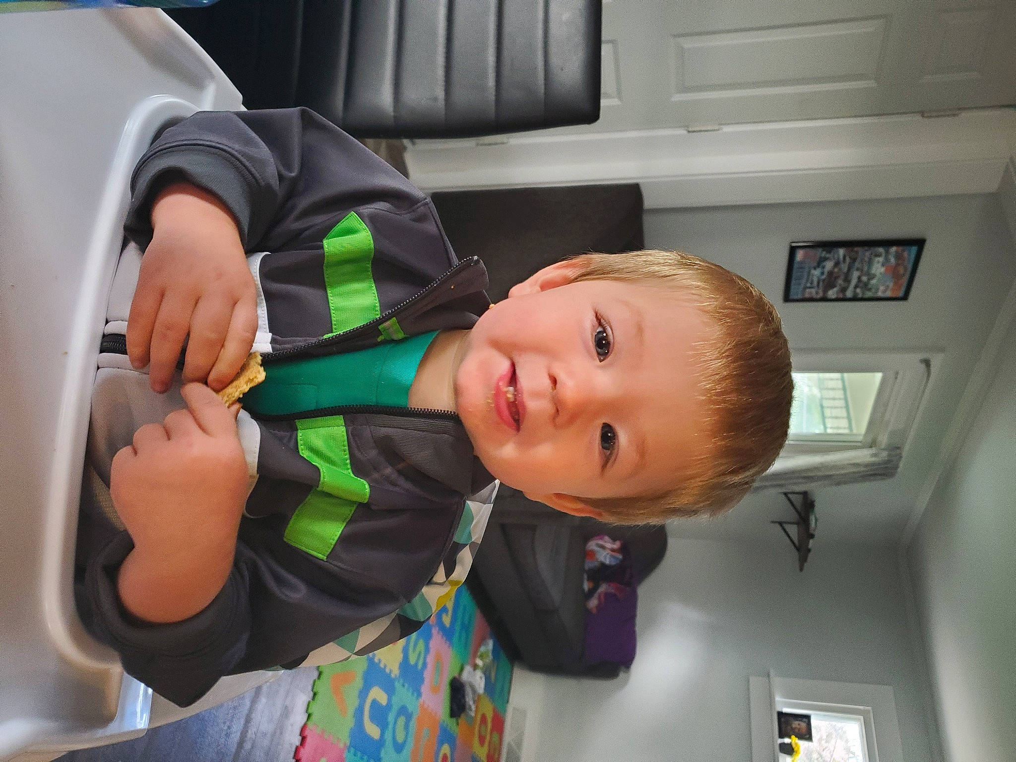 Greyson is registered to the contest to win money with this photo: baby, baby_products, baby_toddler_clothing, chair, cheek, child, comfort, fun, person, picture_frame, room, sitting, smile, t_shirt, toddler