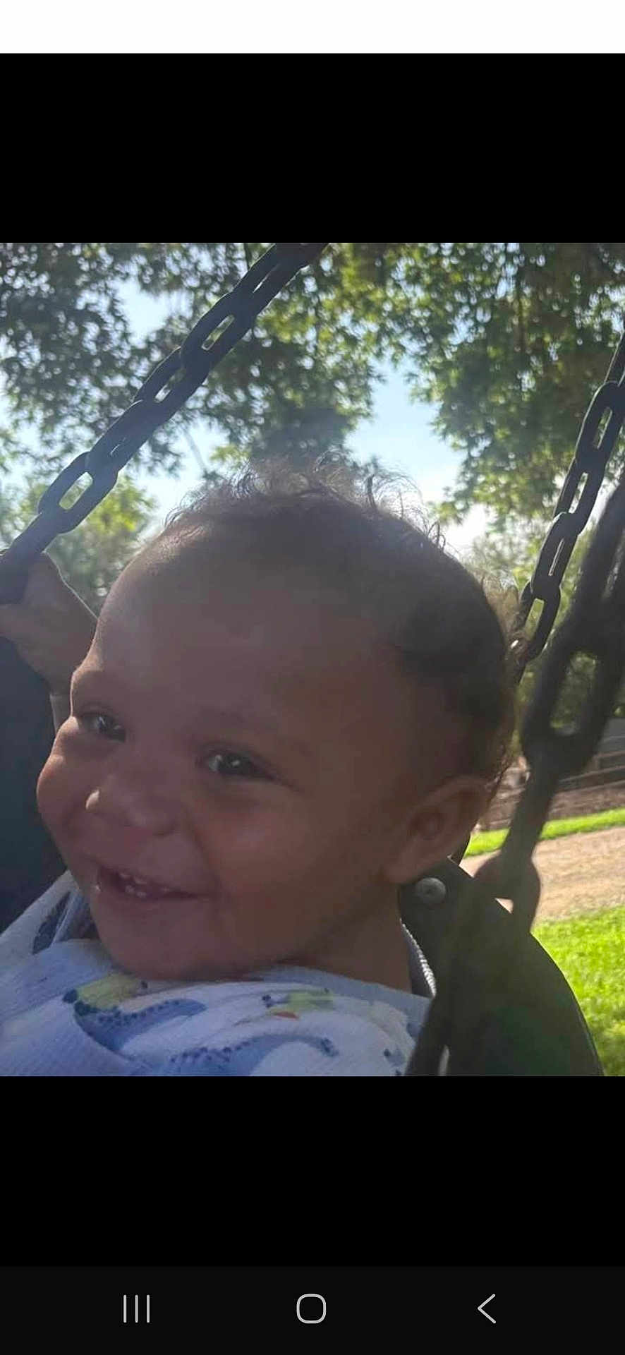 Kayden is registered to the contest to win money with this photo: child, toddler, swing, outdoor, smiling, happy, face, sunlight, trees, sky, playground, chain, baby, joyful, nature, grass, park, casual, person, daylight