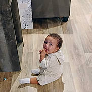 Atreus joined the competition — help win amazing prizes! toddler, child, sitting, floor, wooden_floor, living_room, sofa, couch, home_interior, curious, baby, person, socks, casual_clothing, shadow, furniture, indoor, young_child, cute, looking_up