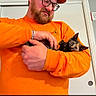 affection, animal, beard, cap, casual, cat, cute, door, glasses, happy, holding, human, indoor, kitten, love, man, orange_clothing, pet, portrait, young_cat
