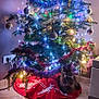 cat, christmas_tree, cozy, decoration, evening, festive, floor, fur, holiday, home, indoor, lights, ornaments, pet, red_tree_skirt, reflection, reindeer_pattern, relaxed, tile, tinsel
