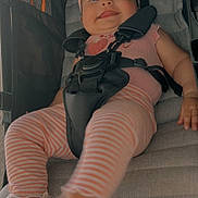 Brenda is registered to the contest to win money with this photo: baby, baby_clothes, child, comfort, cute, footwear, happy, headwear, infant, outdoor_gear, person, pink_headband, playful, safety_harness, sandal, seat, seatbelt, smiling, striped_leggings, stroller