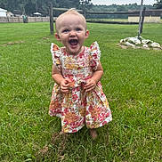 Scarlett is registered to the contest to win money with this photo: child, toddler, baby, floral_dress, dress, smile, laughing, barefoot, grass, lawn, backyard, fence, trees, sky, portrait, outdoor, happy, playful, face, standing