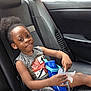 Kasen is registered to the contest to win money with this photo: child, car_interior, seat, water_bottle, paper_cutout, sporty_clothing, basketball_graphic, black_leather, window, seatbelt, young_girl, afro_hair, earrings, casual, relaxed, sitting, backseat, vehicle, daylight, smiling