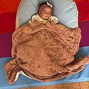 Lyna participe au concours pour gagner de l'argent avec cette photo : baby, blanket, sleeping, headband, floor, mat, colorful, indoor, infant, peaceful, soft, cozy, child, person, cute, resting, pillow, fabric, wrapped, small