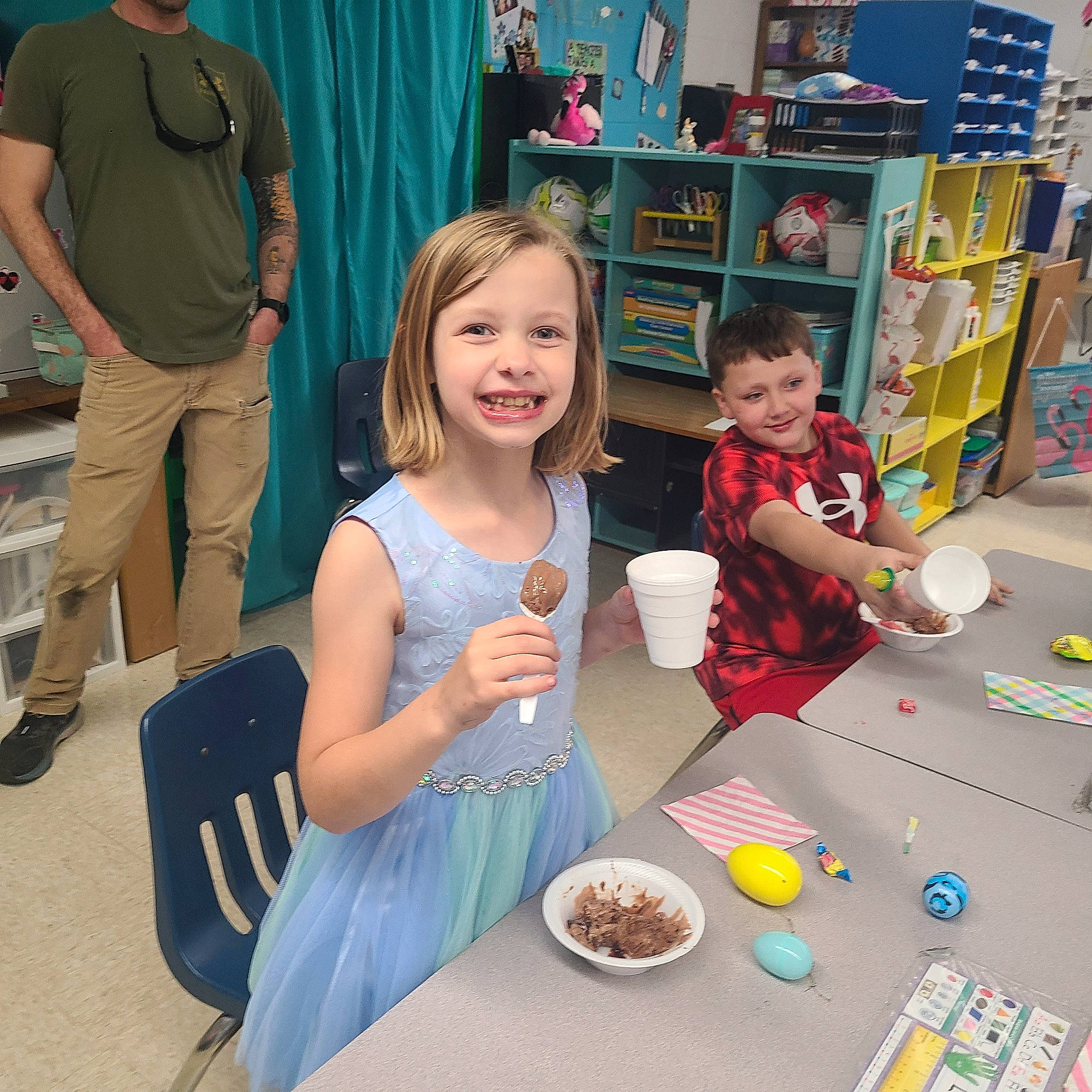 Leah is registered to the contest to win money with this photo: chair, child, event, food, fun, joy, leisure, party, person, plate, recreation, room, sharing, shelf, shorts, smile, summer, t_shirt, table, tableware