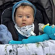 Kaïs a rejoint le concours — aidez-le/la à gagner de superbes lots ! animal_print, baby, bib, blanket, child, cozy, cute, expression, face, hoodie, infant, knitted_toy, outdoor, pavement, person, portrait, sitting, stroller, toy, warm_clothing