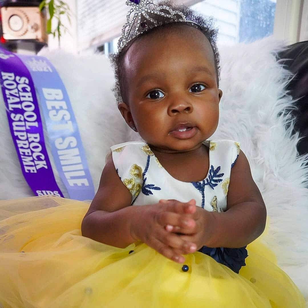 Aaliyah is registered to the contest to win money with this photo: baby, baby_toddler_clothing, beauty, dress, event, face, fun, hair, hairstyle, happy, head, headgear, human, jewellery, people, person, skin, sleeve, toddler, white