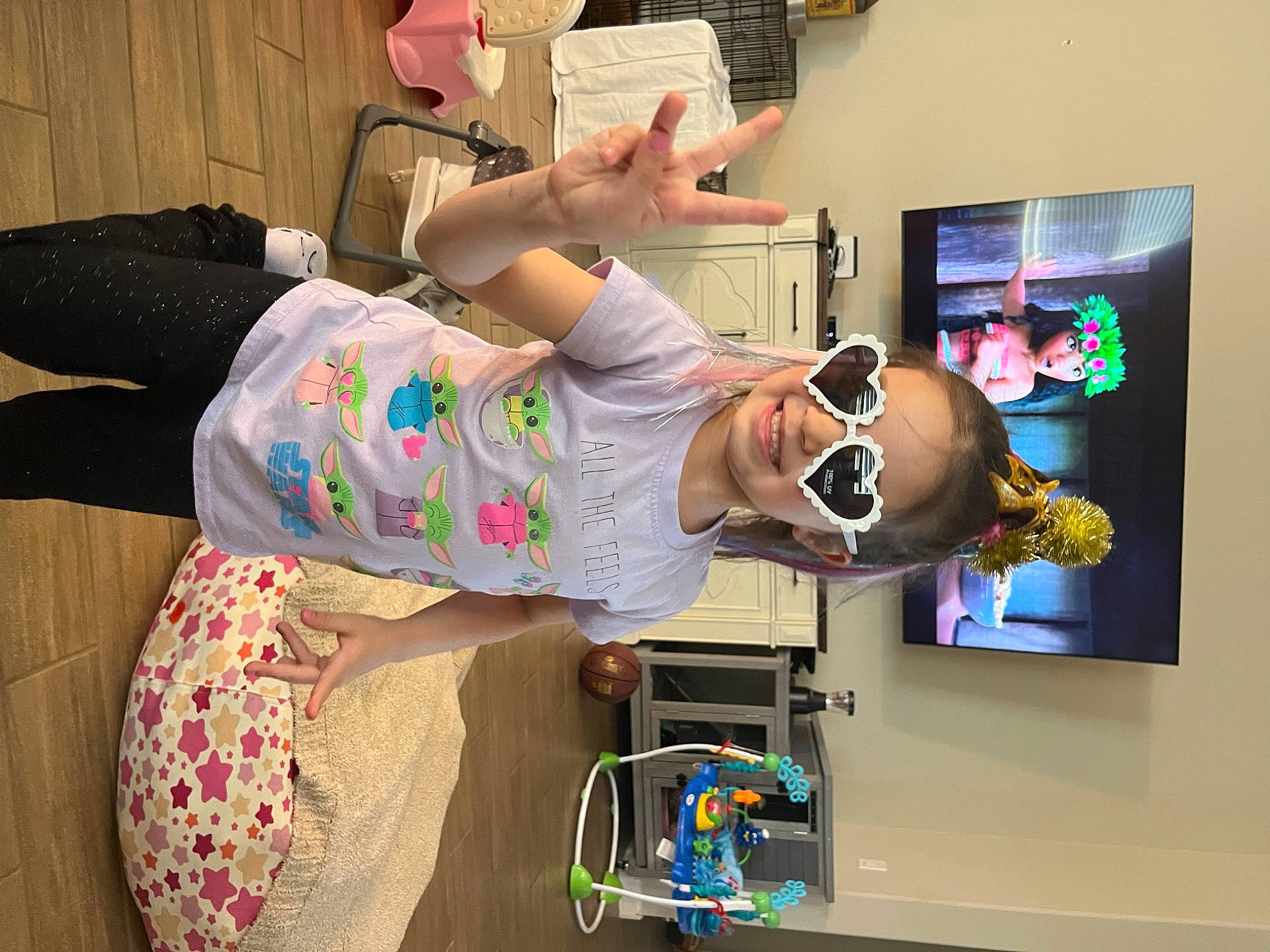 Iliana is registered to the contest to win money with this photo: art, audio_equipment, child, comfort, display_device, eyewear, fun, joy, led_backlit_lcd_display, leisure, machine, magenta, person, play, room, smile, surprise, t_shirt, television_set, toy