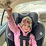 Piper joined the competition — help win amazing prizes! child, car_seat, car_interior, seatbelt, pink_jacket, hat, smiling, road, window, hand, safety, vehicle, travel, young_child, happy, seat, interior, person, cozy, daytime