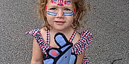 Piper is registered to the contest to win money with this photo: child, toddler, face_paint, 4th_of_july, red_car, volkswagen_jetta, curly_hair, blue_eyes, pink_shoes, animal_toy, checkered_clothing, outdoor, driveway, summer, holiday, cute, smiling, person, nature, greenery