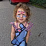 child, toddler, face_paint, 4th_of_july, red_car, volkswagen_jetta, curly_hair, blue_eyes, pink_shoes, animal_toy, checkered_clothing, outdoor, driveway, summer, holiday, cute, smiling, person, nature, greenery