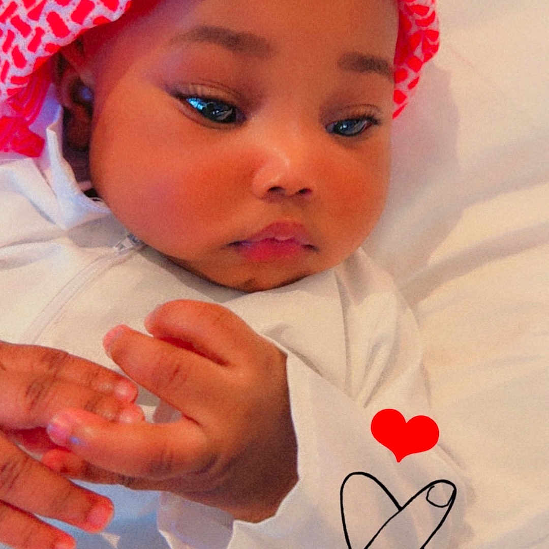 Bamba participe au concours pour gagner de l'argent avec cette photo : accessories, baby, bodypart, bonnet, cap, clothing, cosmetics, face, finger, hand, handwriting, hat, head, jewelry, newborn, person, photography, portrait, ring, text